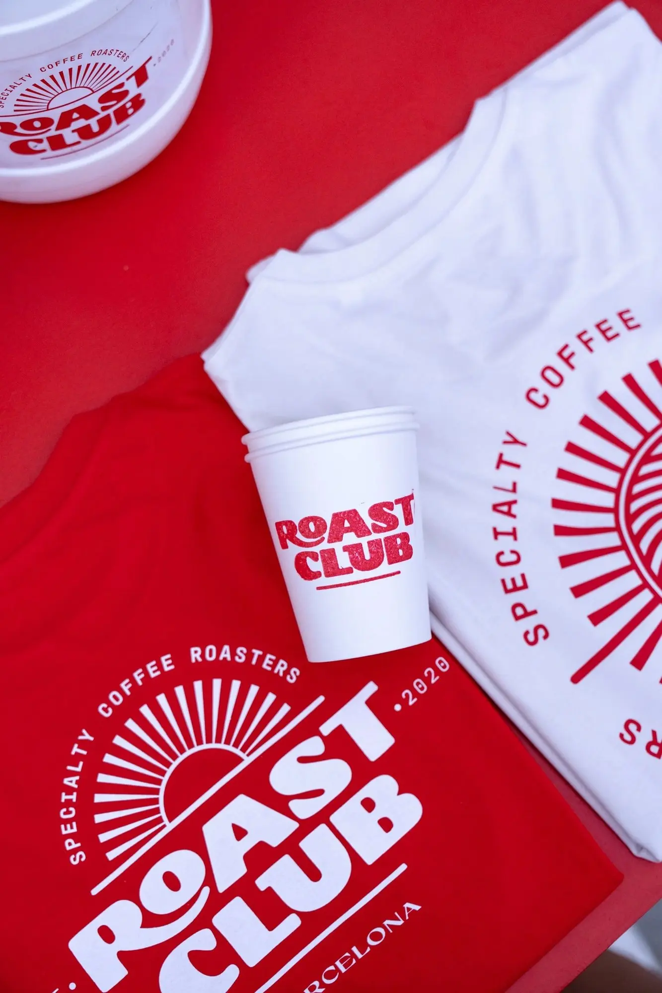 Merchandising de Roast Club sobre fondo rojo