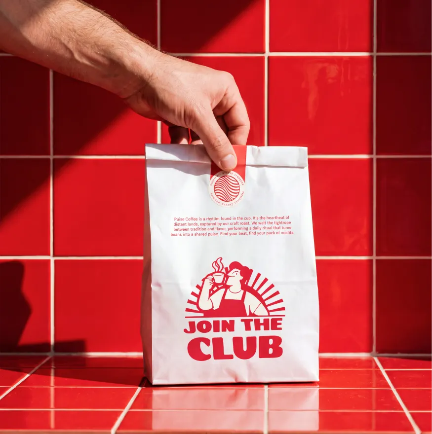 Bolsa de papel JOIN THE CLUB sobre azulejo rojo